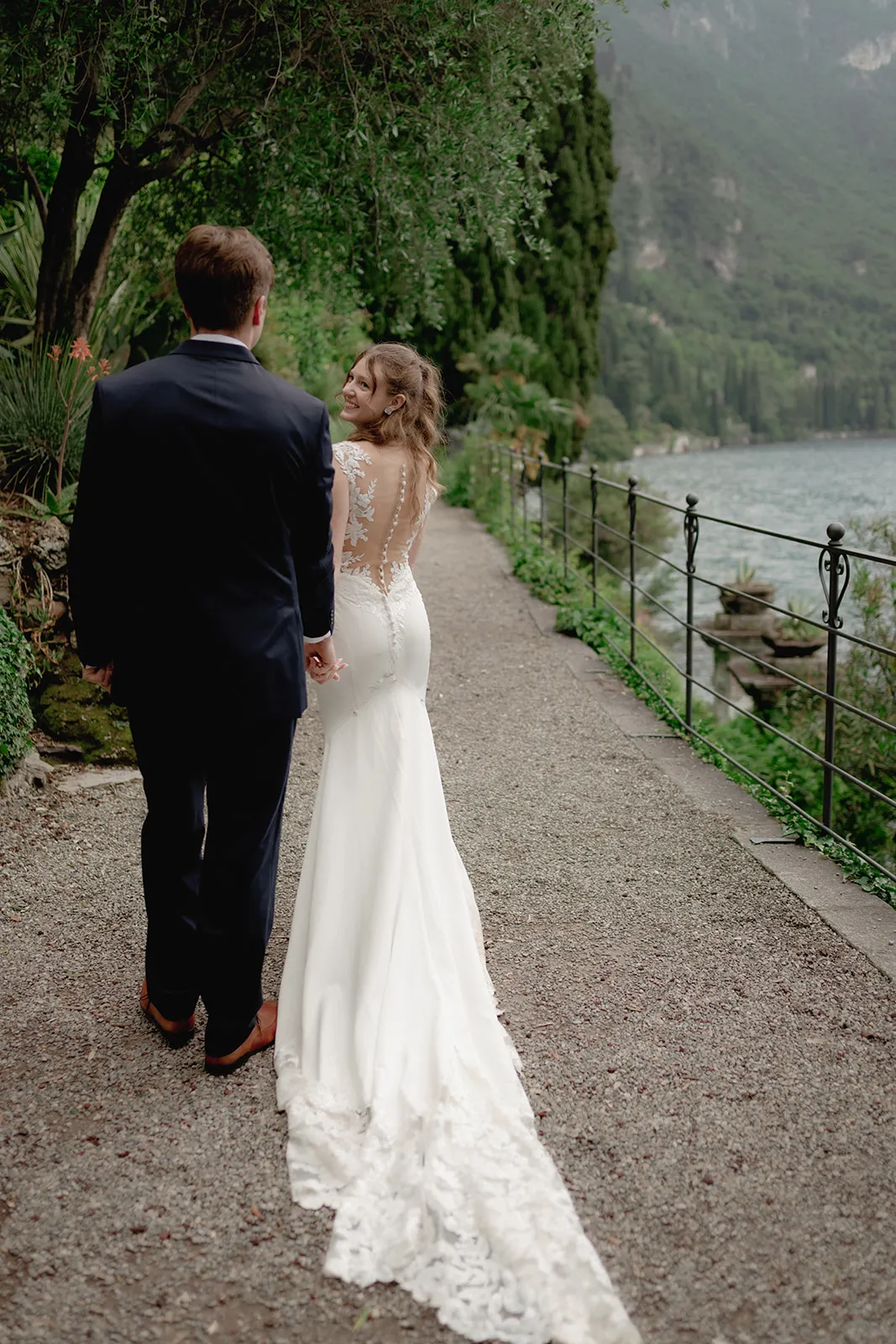 Bride and groom walking hand in hand captured by wedding photographer Lake Como