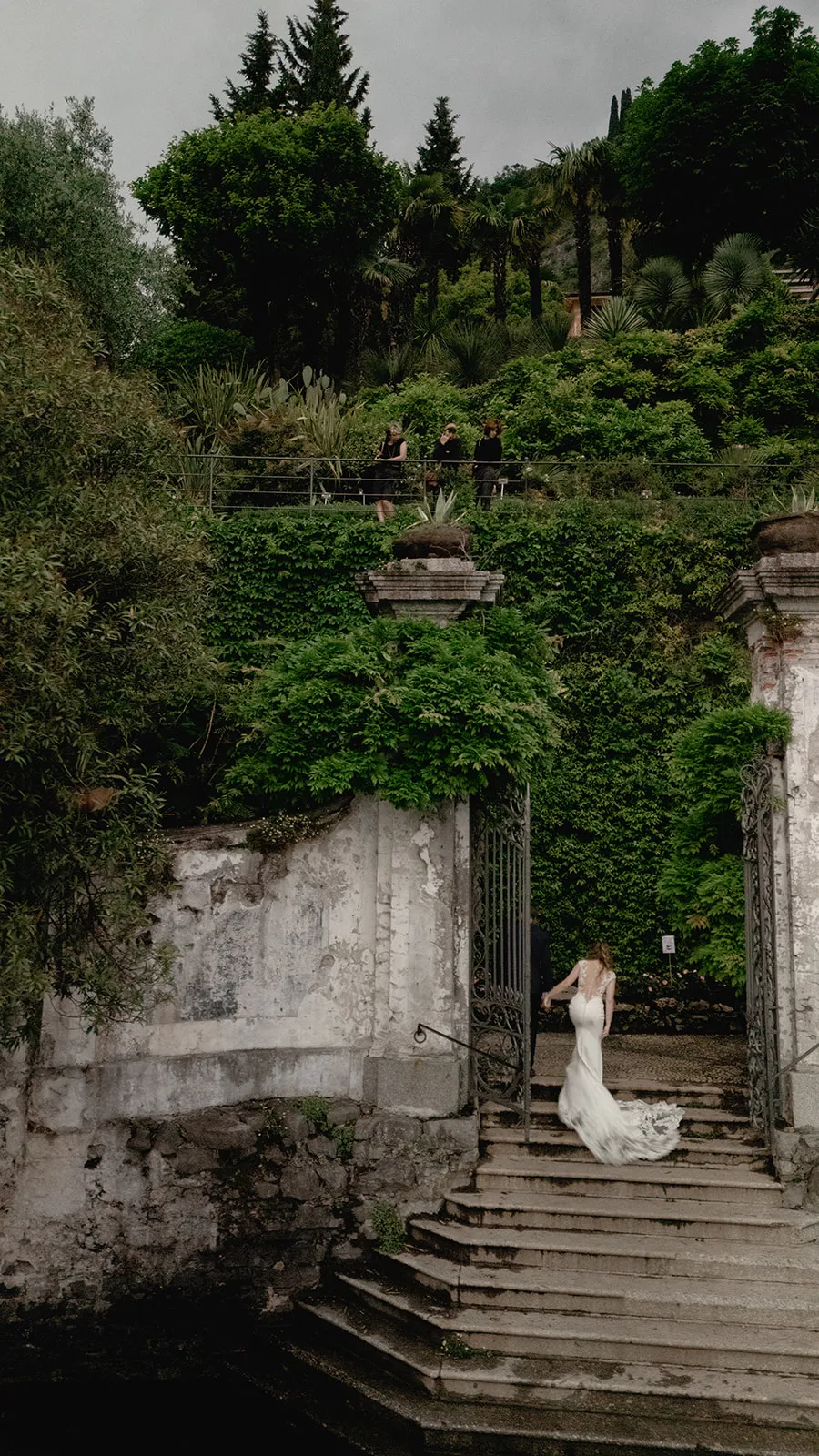 Bride walking up Villa Cipressi garden stairs by wedding photographer Lake Como